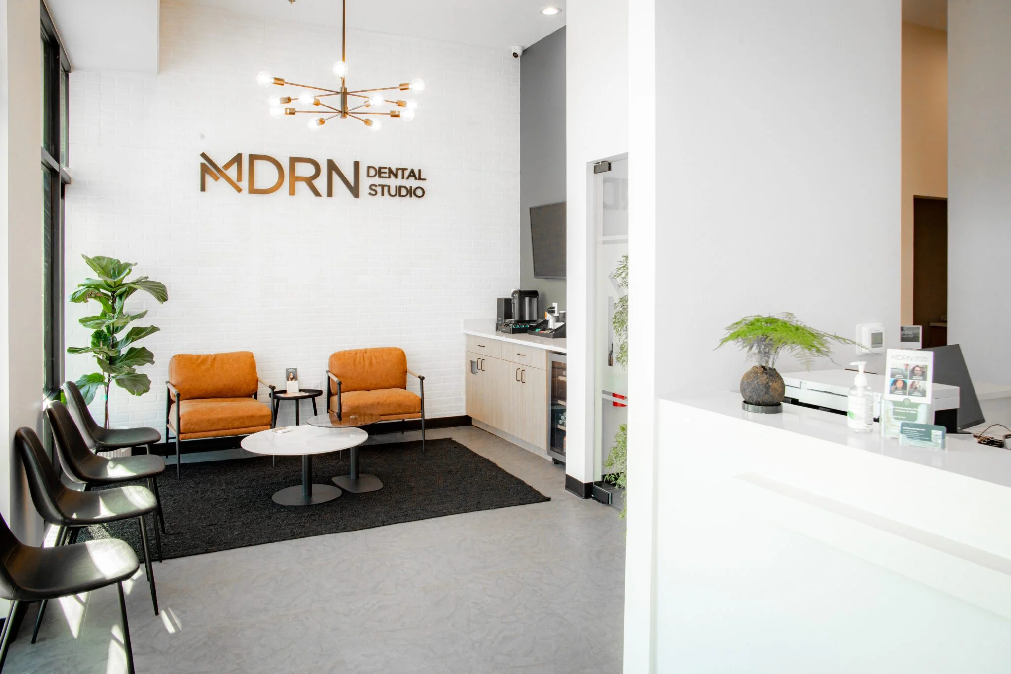The modern, calming reception and treatment area at MDRN Dental Studio in McKinney, TX